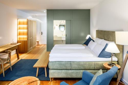 um quarto de hotel com uma cama grande e uma secretária em Hotel zum Glockenturm em Marktl