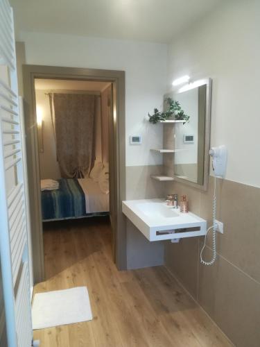 a bathroom with a sink and a mirror and a bed at La Libellula in Villorba