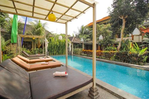 a swimming pool next to a villa with a swimming pool at Pondok Kutuh Guest House in Ubud