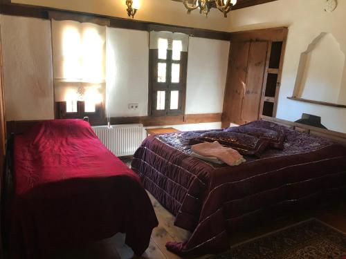 a bedroom with two beds and a chandelier and windows at Çamlıca Konak Çarsı in Safranbolu