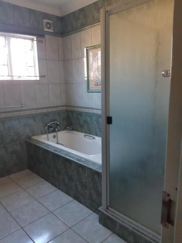 a bathroom with a bath tub and a window at Angela's Place in Durban