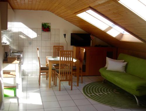 インメンシュタット・イム・アルゴイにあるHolidays in Allgauのリビングルーム(テーブル、緑のソファ付)