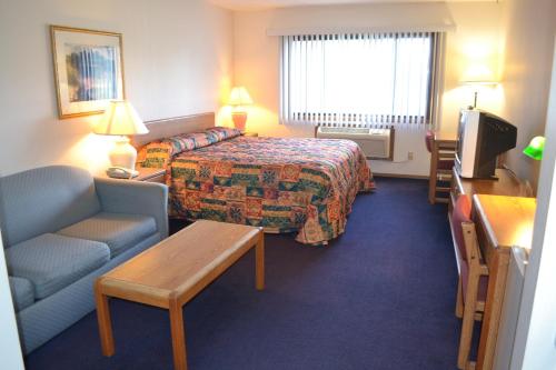 a hotel room with a bed and a couch at Sky Lodge Inn & Suites - Delavan in Delavan
