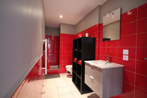 トゥールーズにあるLes Minimesの赤いバスルーム(洗面台、トイレ付)