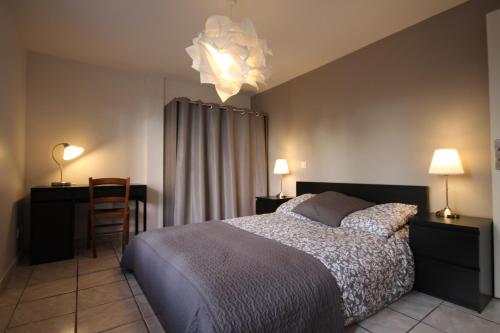 une chambre avec un lit, un bureau et une chaise dans l'établissement Les Minimes, à Toulouse