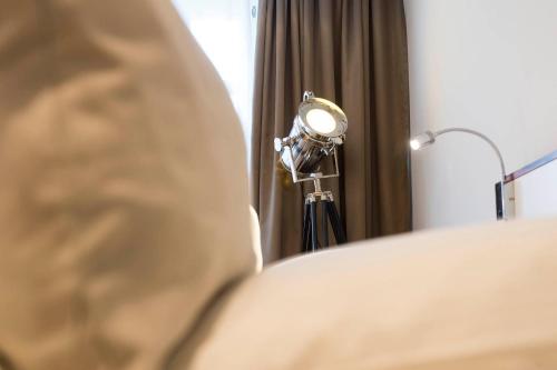 a lamp sitting on a bed next to a bed gmaxwell gmaxwell gmaxwell at Hotel Storck in Bad Laer
