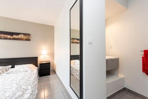 une chambre avec un lit et un miroir dans l'établissement Le Pastel, à Toulouse