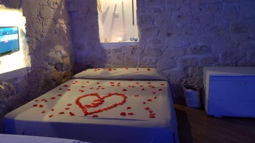 una stanza con un letto con cuori rossi sopra di Alloggio Turistico Suite Nino a Ceglie Messapica