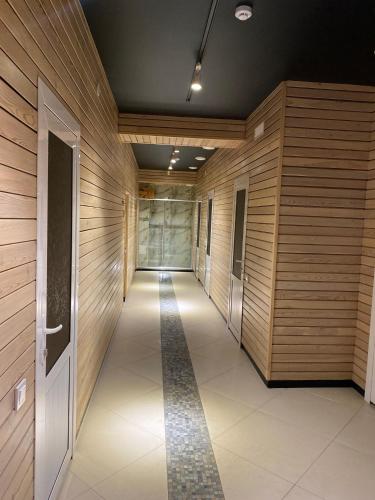 a hallway with wooden walls and a tile floor at Barhat Hotel & SPA in Taraz