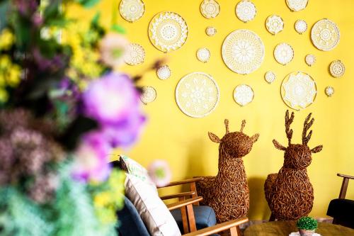 two wooden animals sitting on a wall with plates at Baan Suan Krung Kao in Phra Nakhon Si Ayutthaya