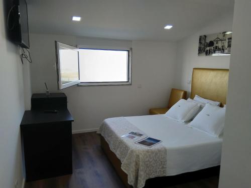 a small bedroom with a bed and a window at myCasa in Espinho