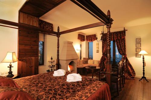 a bedroom with a large bed with a fireplace at Vaela Hotel Cultural Resort in Elatochori