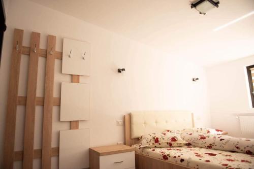 a bedroom with a bed and a white wall at Casa Florus in Şieu
