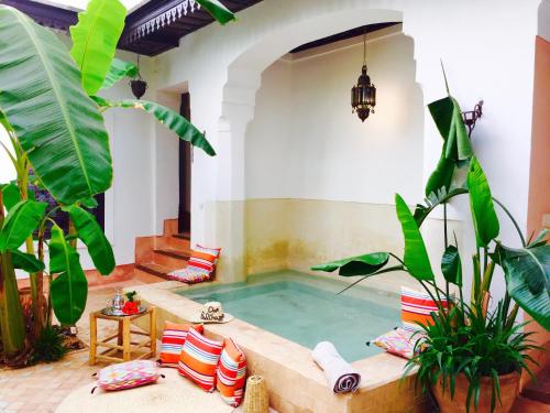a hot tub in a room with plants at Riad Dar Balthazar in Marrakech