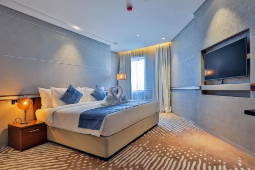 a bedroom with a large bed and a flat screen tv at VIP Hotel Doha Qatar in Doha