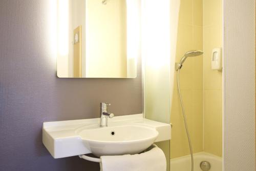 a bathroom with a white sink and a mirror at B&B HOTEL Montpellier 2 in Saint-Jean-de-Védas