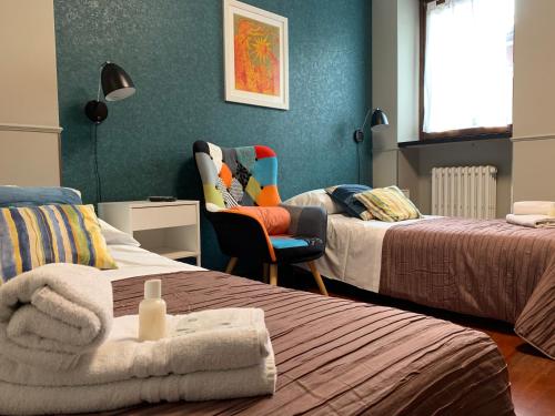 a room with two beds and a chair in a room at B&B Casanova in Verona