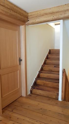 an empty hallway with a door and a staircase at BnB Ai Cav Calanca in Arvigo
