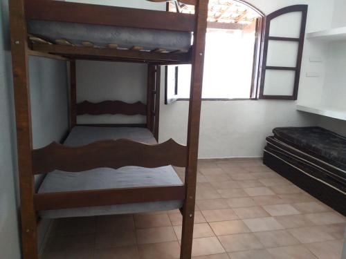 two bunk beds in a room with a window at Casa Massaguaçu in Caraguatatuba