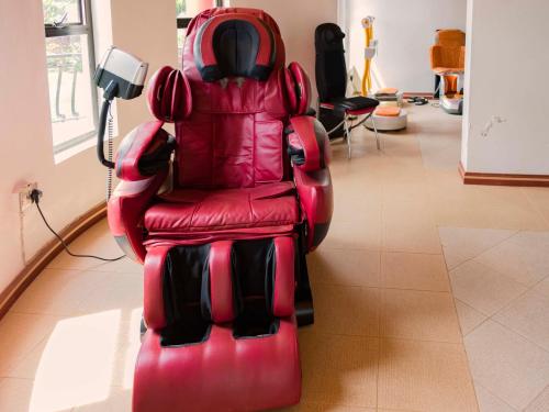 a red leather chair sitting in a room at Fort Fun City Hotel Fort Portal in Fort Portal