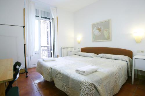 een slaapkamer met een bed met twee handdoeken erop bij Pensión San Telmo / San Juan in San Sebastian