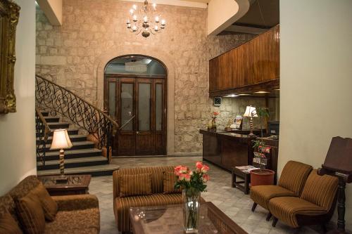 a living room with a couch and a table and stairs at Hotel Roma in Durango