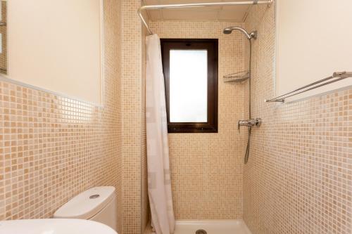 baño con aseo y ducha con ventana en Lets in the Sun Calablanca, en La Cala de Mijas