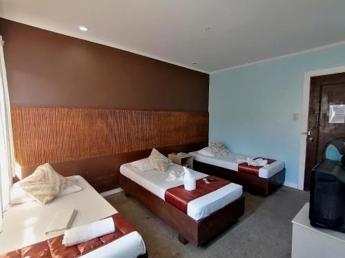 Habitación de hotel con 2 camas y TV en RB Bed and Breakfast, en Kalibo