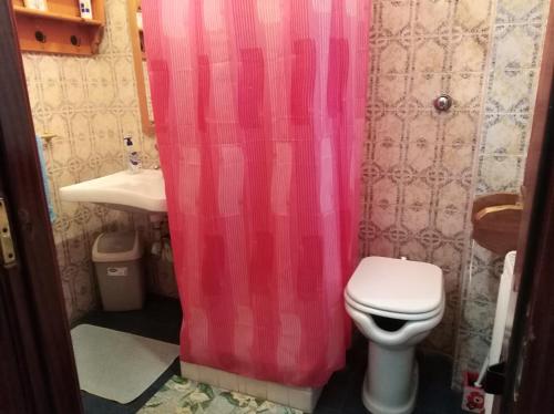 ein Badezimmer mit einem rosa Duschvorhang und einem WC in der Unterkunft Le Piagge in Nemi
