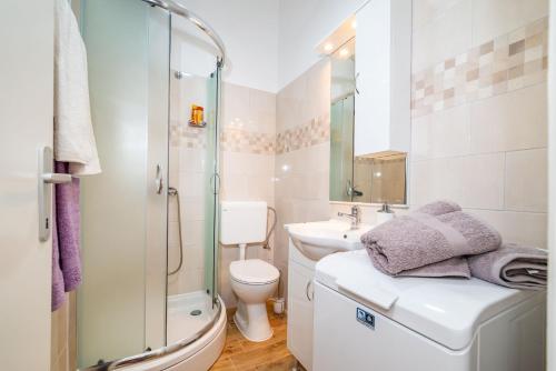 y baño con ducha, aseo y lavamanos. en History Apartments Center, en Zadar