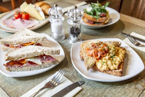 a table topped with plates of food with sandwiches at The Millers Arms Inn in Canterbury
