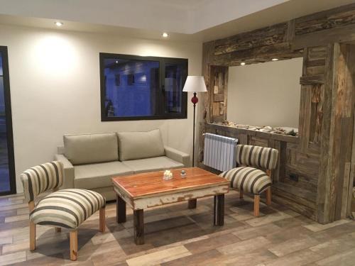 a living room with a couch and a table at Fitz Roy Hostería de Montaña - El Chaltén in El Chalten