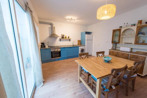 a kitchen with a wooden table and blue cabinets at River Ebro Apartments in Móra d'Ebre