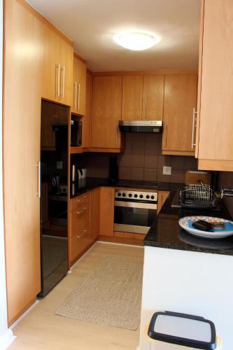 a kitchen with wooden cabinets and a black counter top at 1105 Portico in Bloubergstrand