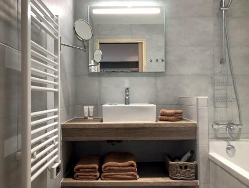 une salle de bain avec un lavabo, un miroir et des serviettes dans l'établissement Les Tchanquées, à Le Touquet-Paris-Plage