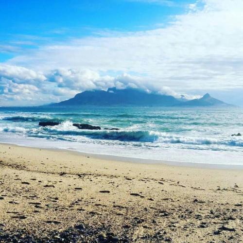 a view of a beach with a mountain in the background at 1105 Portico in Bloubergstrand