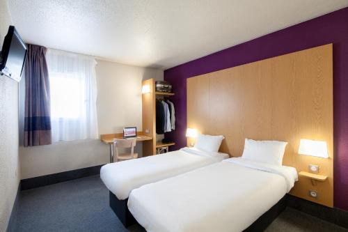 Tempat tidur dalam kamar di B&B HOTEL Paris Est Bondy