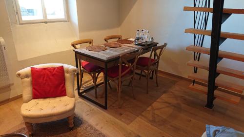 a dining room table and chairs with a red pillow at Alter Markt LOFT in Salzburg