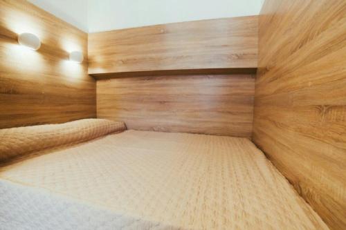 リヴィウにあるApartment on Kulisha 29-аの木製の壁のベッドルーム1室(ベッド1台付)