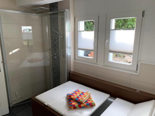 uma casa de banho com um chuveiro e um banco com uma toalha em Buxhaus em Solingen