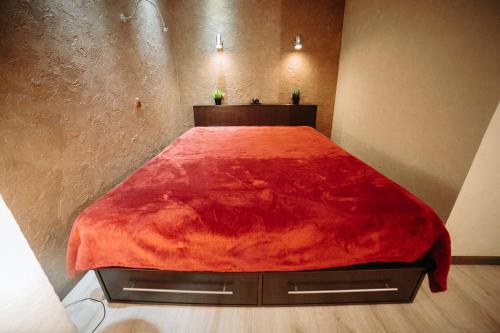 a bed with a red blanket on it in a room at Apartment on Lenin Avenue in Gomel