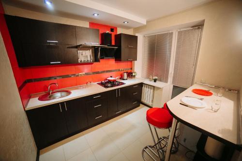 cocina con fregadero y pared roja en Apartment on Lenin Avenue, en Gomel