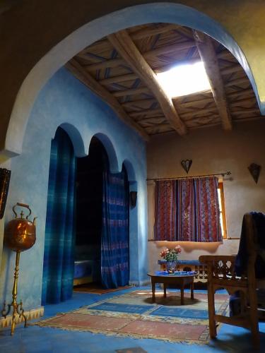 a living room with a table and a window at Le Chant Des Palmiers in Agdz