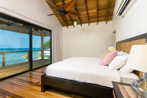 En eller flere senge i et værelse på Vivaro Roatan Beachfront