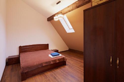 1 dormitorio con 1 cama y suelo de madera en Apartment on Lychakivska, en Leópolis