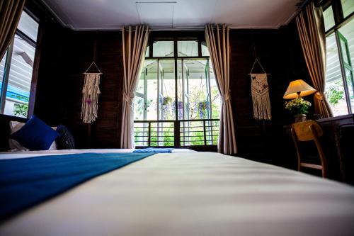 a bedroom with a large bed and a window at Baan Suan Krung Kao in Phra Nakhon Si Ayutthaya