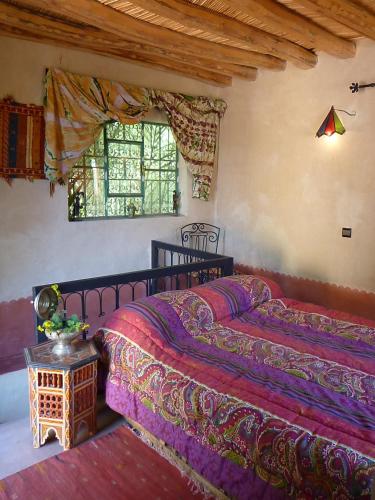 a bedroom with two beds and a window at Le Chant Des Palmiers in Agdz