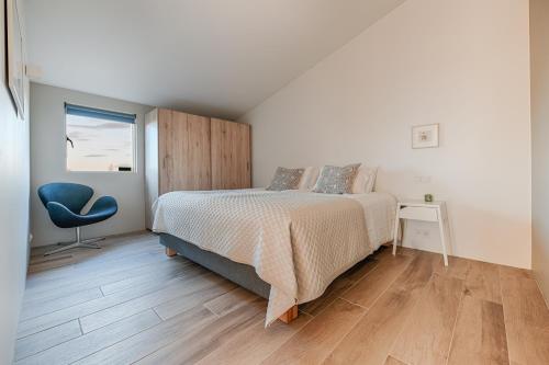 um quarto com uma cama, uma cadeira e uma janela em Kerbyggd: Luxury house and cottage in golden circle em Selfoss