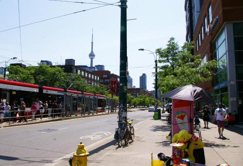 a city street with people walking on the sidewalk at The Alexandra Hotel in Toronto