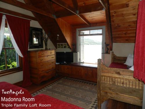 a bedroom in a log cabin with a bed and a window at TwoAngels in Knysna